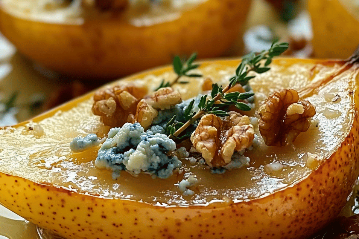 Baked pears topped with blue cheese, walnuts, and drizzled with honey, garnished with fresh thyme.